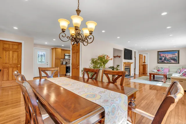 a dining room with furniture a chandelier and wooden floor