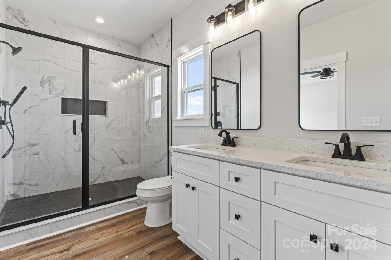 234 Briggs Road Salisbury, NC 28147 - Photo 21 of 35 a bathroom with a double vanity sink toilet mirror and shower