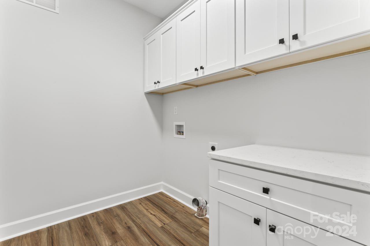 234 Briggs Road Salisbury, NC 28147 - Photo 23 of 35 a view of white cabinets and utility room with wooden floor
