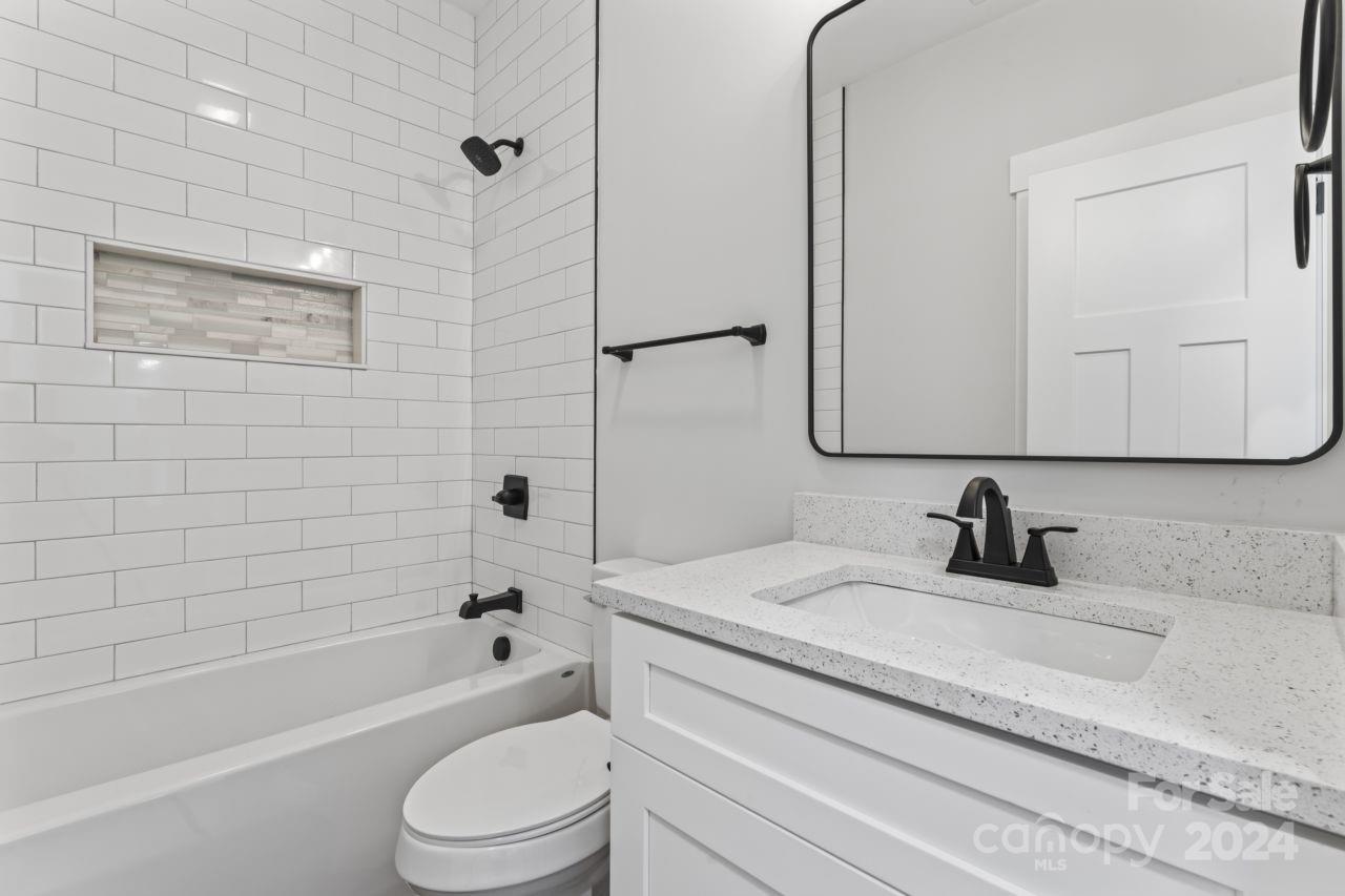 234 Briggs Road Salisbury, NC 28147 - Photo 27 of 35 a bathroom with a granite countertop bathtub shower sink vanity mirror and toilet