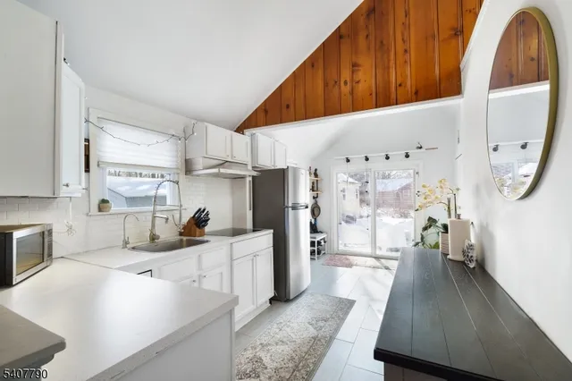 a kitchen with stainless steel appliances a stove a sink a refrigerator and cabinets