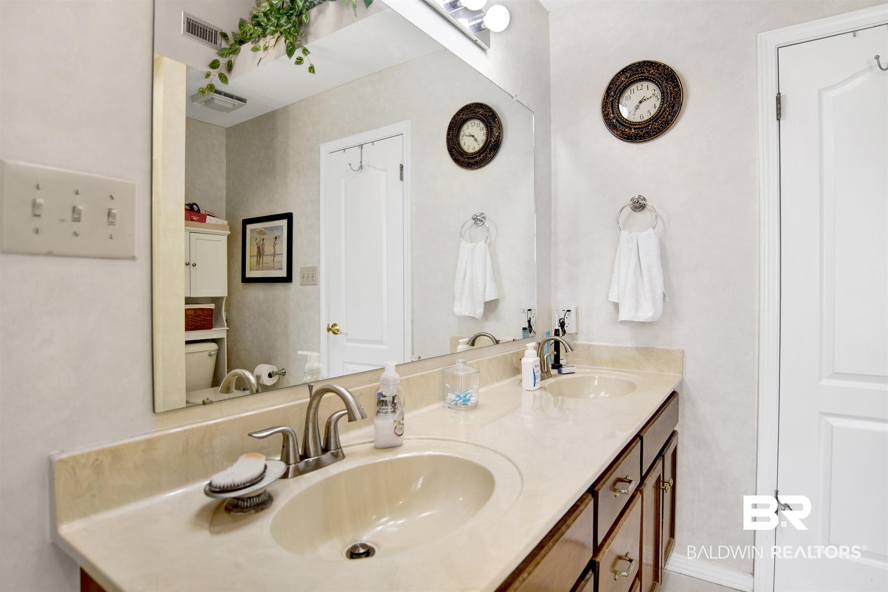 107 Virginia Circle Daphne, AL 36526 - Photo 18 of 47 Double vanity with integrated sinks and a light-toned countertop, set against a full-width wall mirror