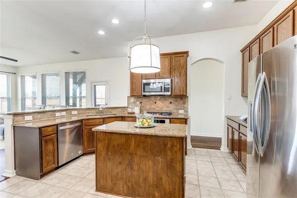 a kitchen with stainless steel appliances granite countertop a sink stove and refrigerator