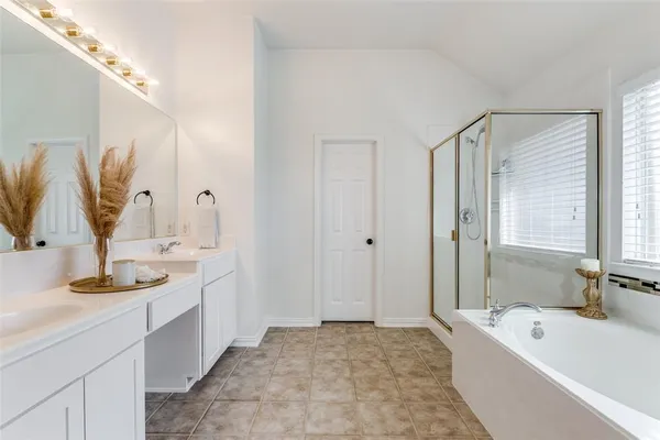 a bathroom with a tub sink and mirror