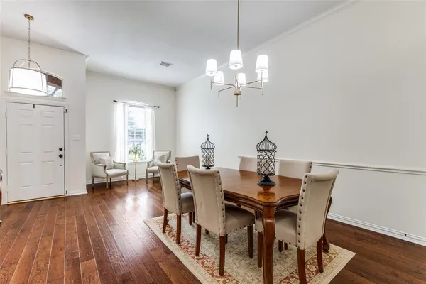 a view of a dining room with furniture wooden floor and chandelier