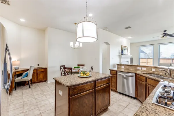 a kitchen with stainless steel appliances granite countertop a stove a sink and a refrigerator