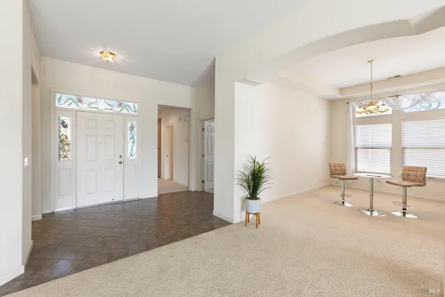a view of kitchen with stainless steel appliances kitchen island granite countertop lots of white cabinets