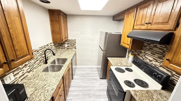 a kitchen with a stove a sink and a refrigerator