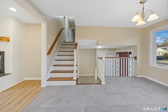 a view of empty room with stairs and wooden floor