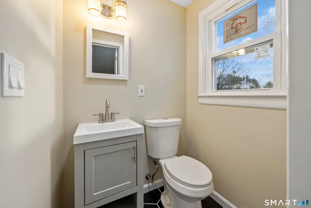 a bathroom with a toilet a sink and mirror