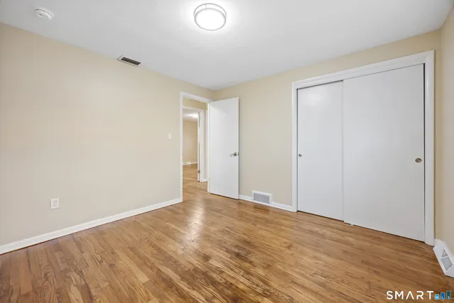a view of an empty room with wooden floor