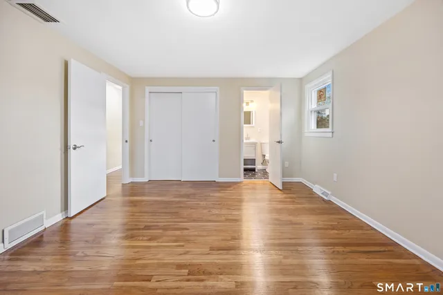 a view of an empty room with wooden floor