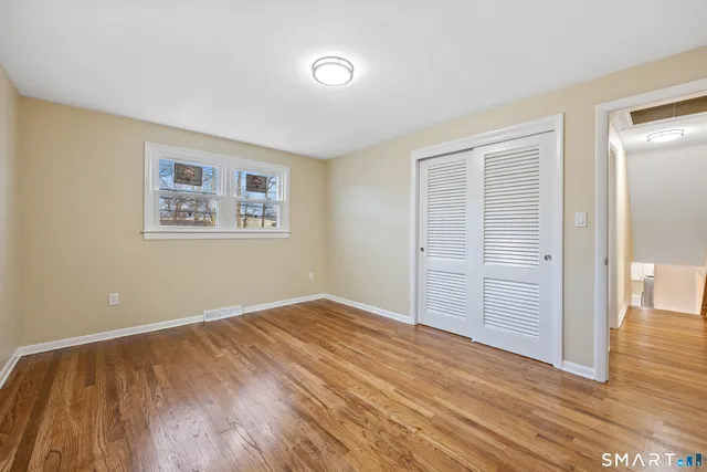 a view of an empty room with wooden floor