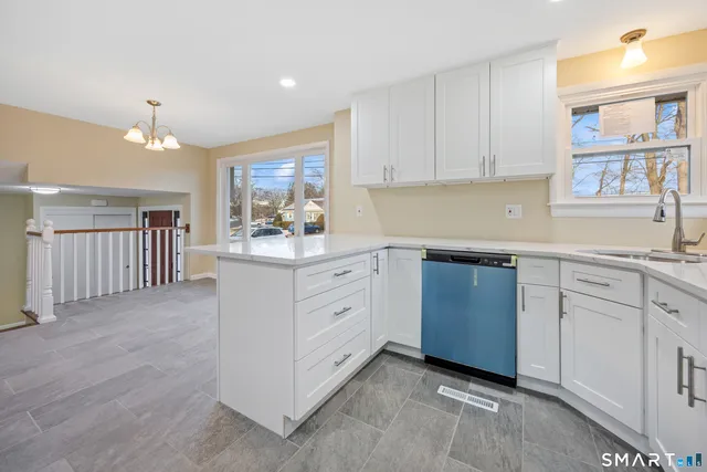 a kitchen with white cabinets and sink