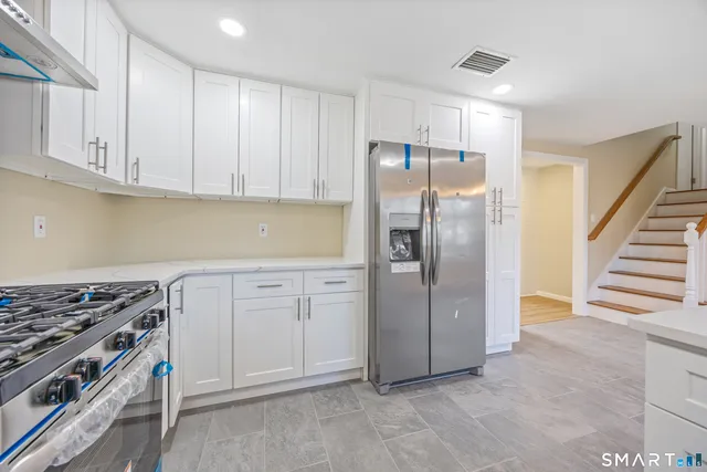 a kitchen with white cabinets and stainless steel appliances