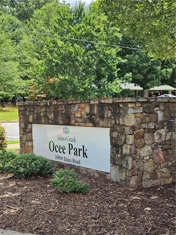 a sign of golf club on a stone wall