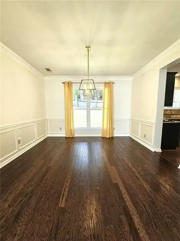 a view of empty room with wooden floor and fireplace