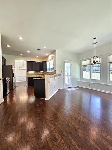 an open kitchen with a refrigerator and a stove top oven