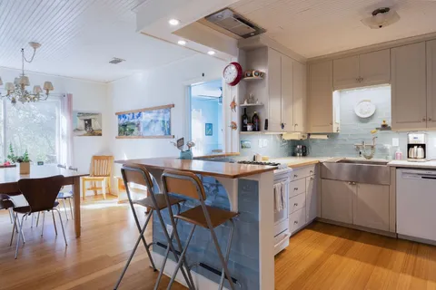a kitchen with a table chairs sink and cabinets