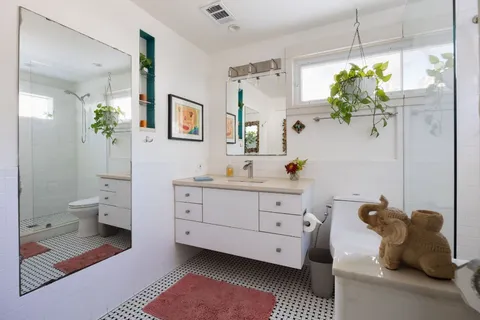 a spacious bathroom with a double vanity sink mirror and bathtub