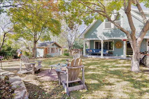 a view of a house with a yard patio and fire pit