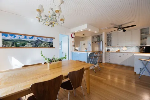 a view of a dining room with furniture a chandelier and wooden floor