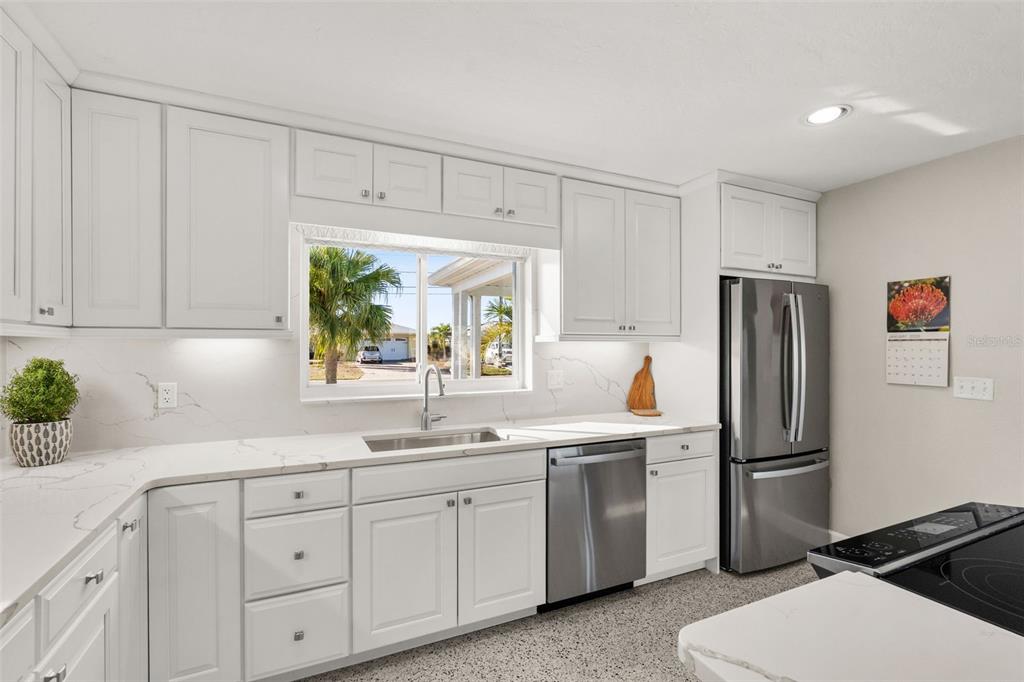 4908 Arlington Road Palmetto, FL 34221 - Photo 12 of 36 a kitchen with a sink stainless steel appliances and cabinets