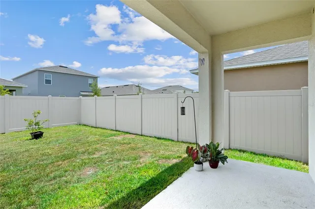 a vase of flowers sitting on a floor in front of a door