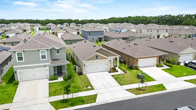 an aerial view of residential houses with outdoor space and street view