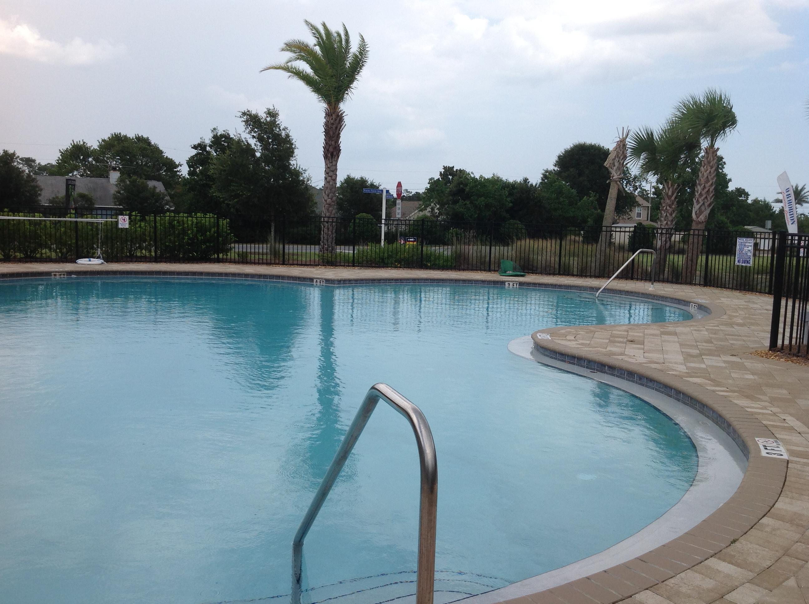 2131 Wilsons Plover Circle Navarre, FL 32566 - Photo 18 of 19 a view of a swimming pool with lake and trees in the background