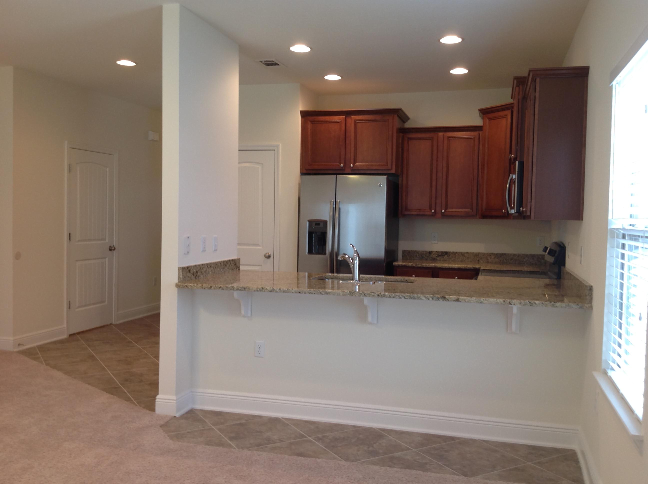 2131 Wilsons Plover Circle Navarre, FL 32566 - Photo 5 of 19 a kitchen with kitchen island granite countertop a sink and a refrigerator