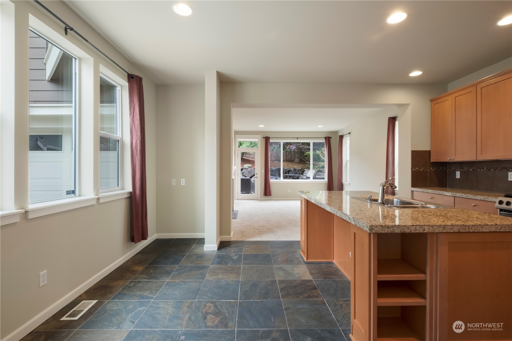 574 Lyons Place Northeast Renton, WA 98059 - Photo 11 of 39 a room with kitchen island granite countertop a large window and a sink