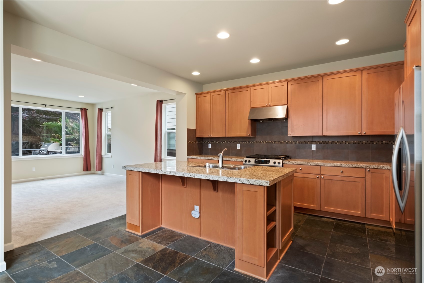 574 Lyons Place Northeast Renton, WA 98059 - Photo 12 of 39 a kitchen with stainless steel appliances granite countertop a stove a sink and a microwave