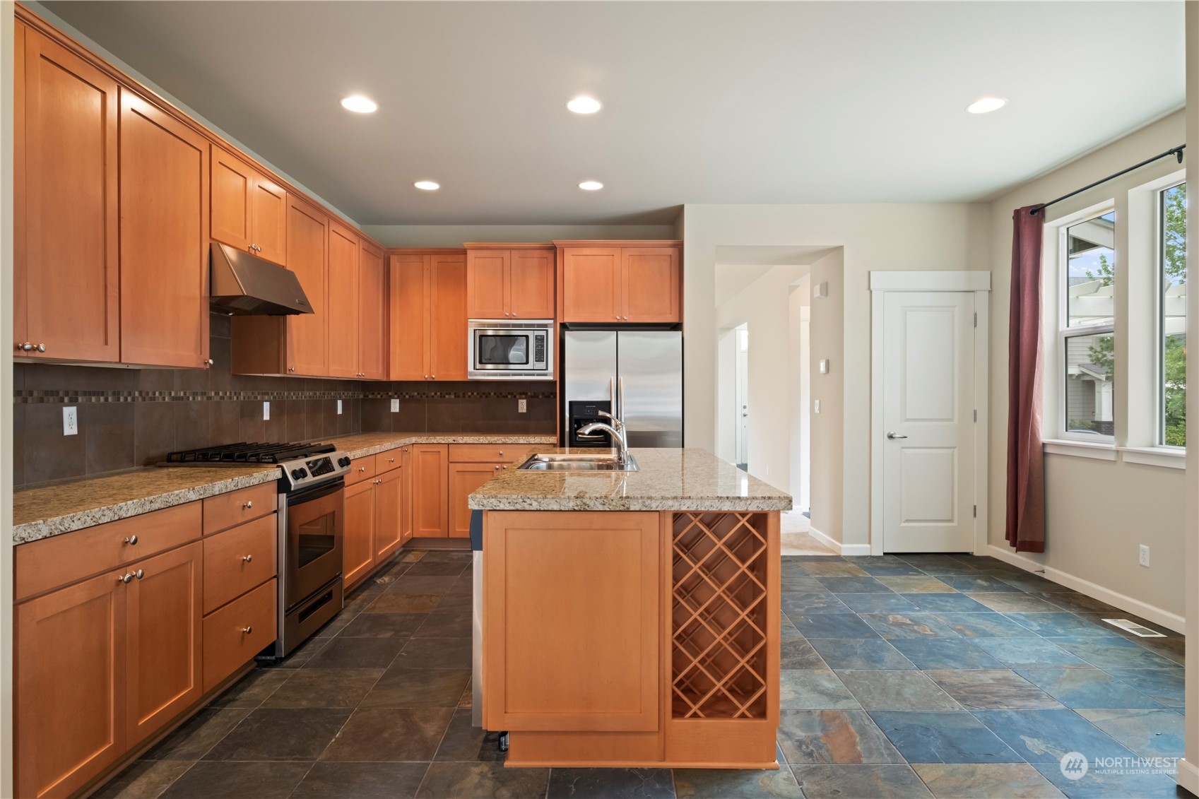 574 Lyons Place Northeast Renton, WA 98059 - Photo 13 of 39 a large kitchen with stainless steel appliances granite countertop a stove a sink and a refrigerator
