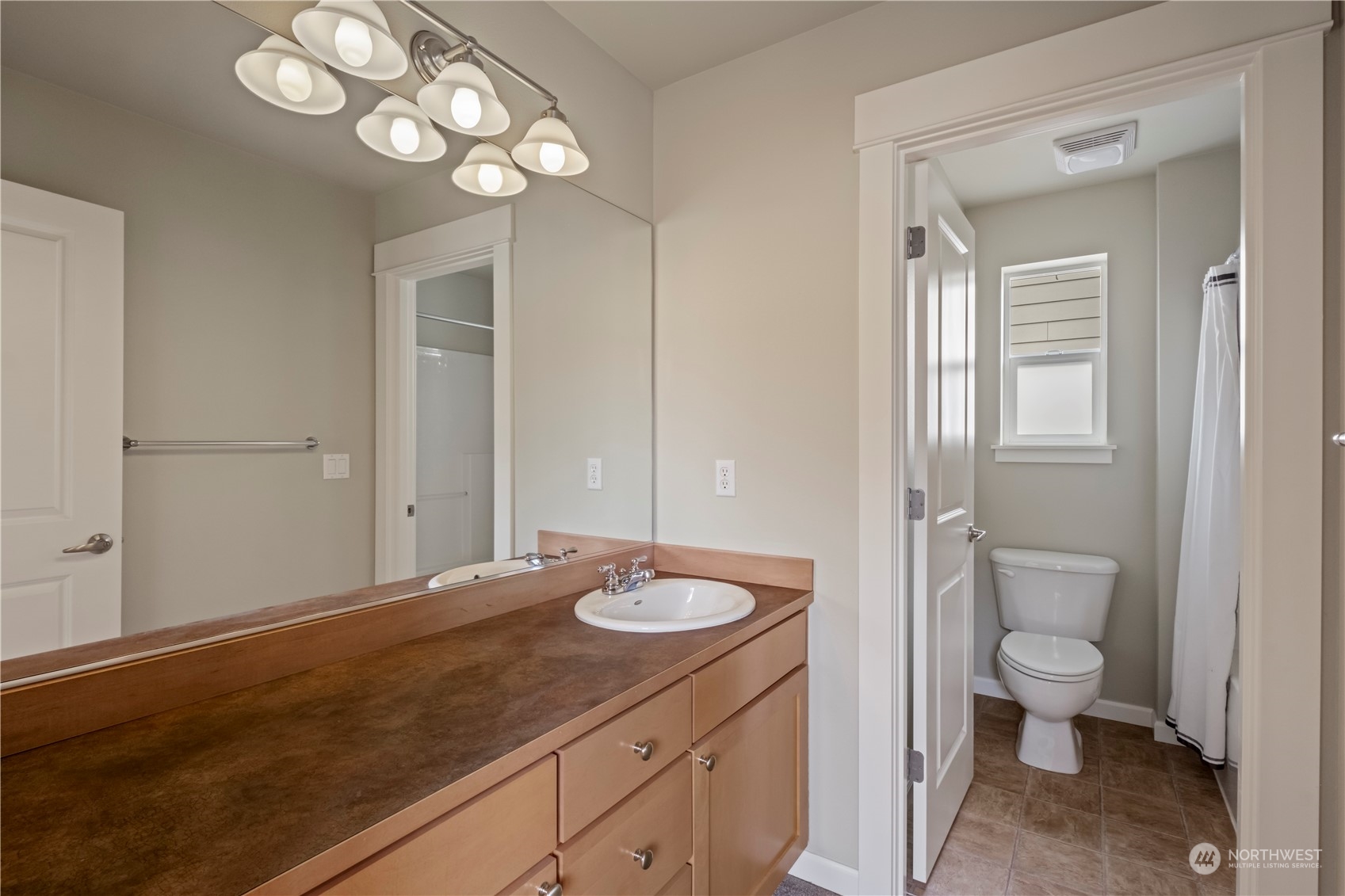 574 Lyons Place Northeast Renton, WA 98059 - Photo 20 of 39 a bathroom with a sink a toilet and a large mirror