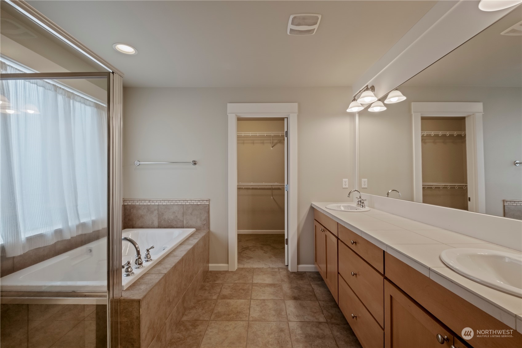 574 Lyons Place Northeast Renton, WA 98059 - Photo 27 of 39 a spacious bathroom with a granite countertop sink a toilet a mirror and shower