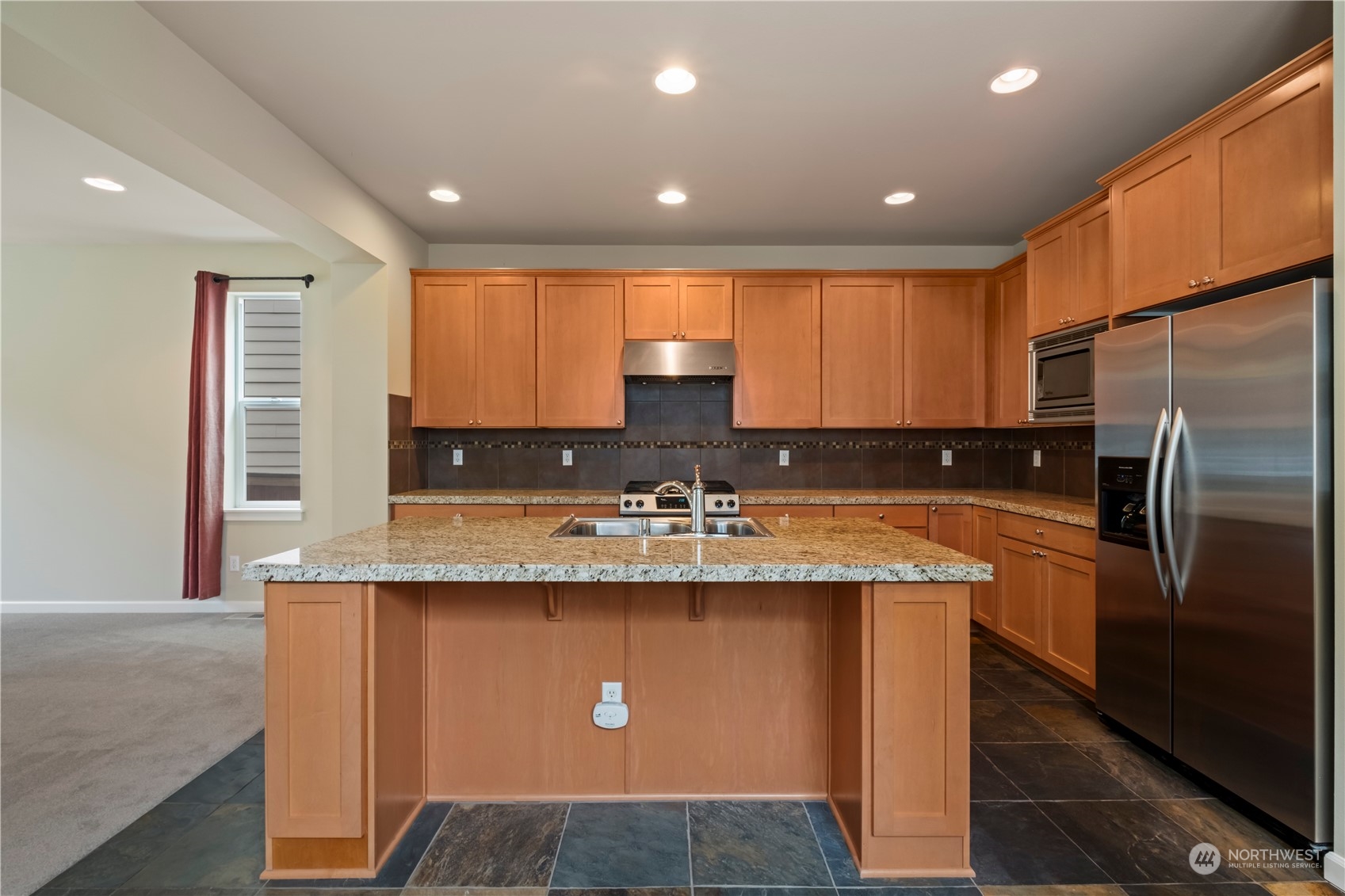574 Lyons Place Northeast Renton, WA 98059 - Photo 9 of 39 a kitchen with stainless steel appliances granite countertop a sink a stove and a refrigerator