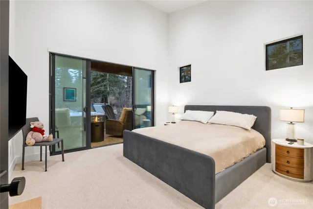 a bedroom with a bed and large windows