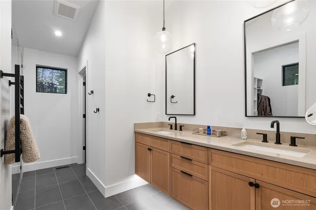 a bathroom with a double vanity sink a mirror and a shower