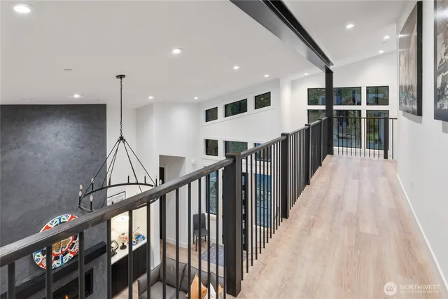 a view of a hallway with wooden floor and windows