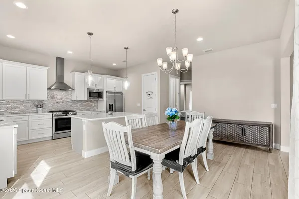a view of a dining room with furniture and chandelier