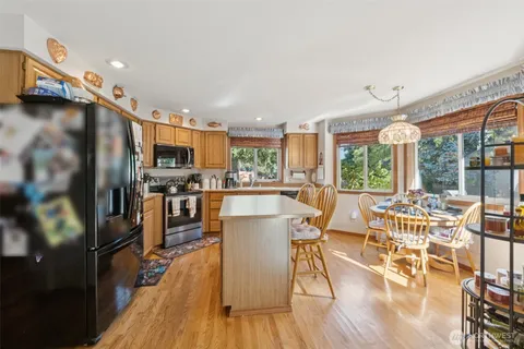 a view of a dining room with furniture a kitchen view and wooden floor