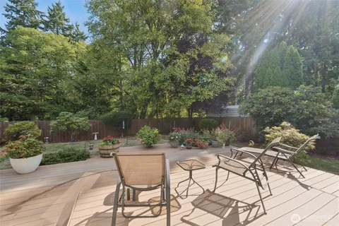 a view of backyard with seating space and trees in the background
