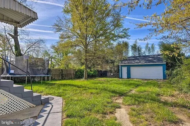 a view of a chair and table in backyard of the house