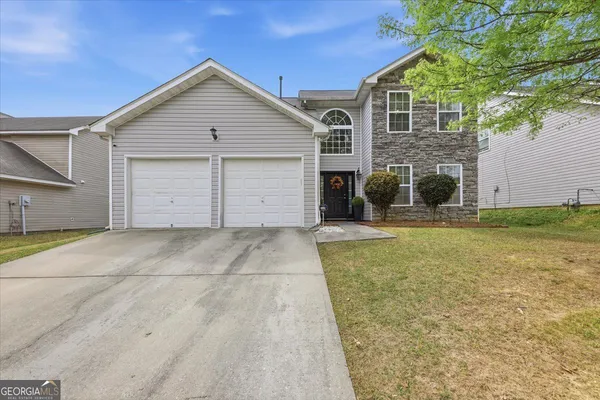 a view of a house with a yard and garage