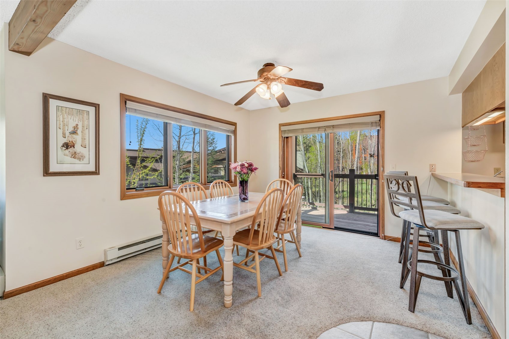 1675 Ranch Road, Unit 411 Steamboat Springs, CO 80487 - Photo 10 of 48 Dining area with ceiling fan, a healthy amount of sunlight, light colored carpet, and baseboard heating