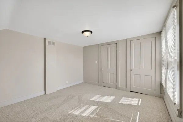 a view of a room with an empty space and windows