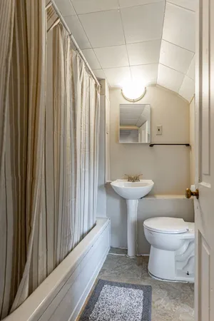 a bathroom with a toilet a sink and mirror
