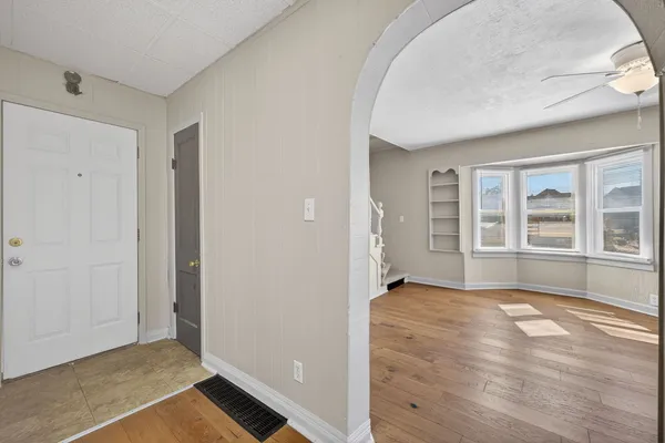 an empty room with wooden floor and windows