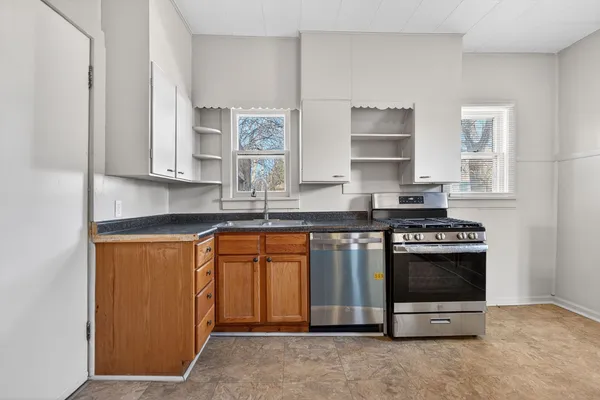 a kitchen with stainless steel appliances granite countertop a stove a sink and a microwave
